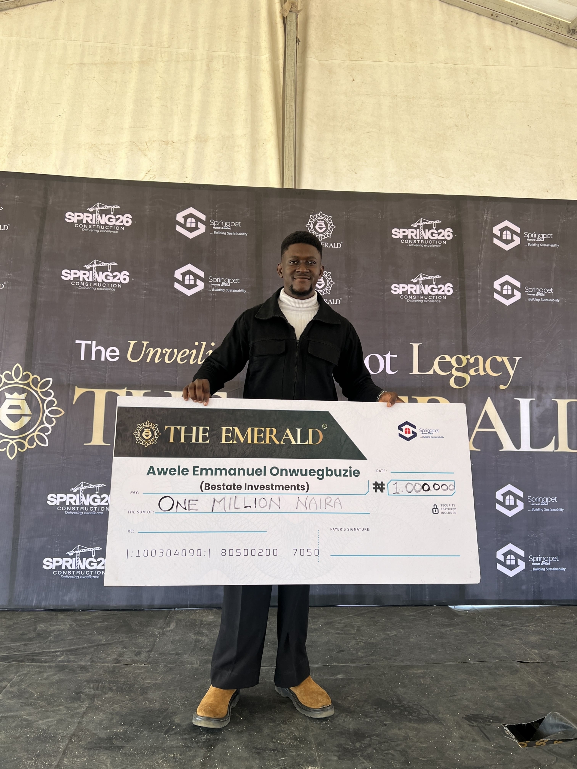 Awele Emmanuel holding a one million naira incentive cheque